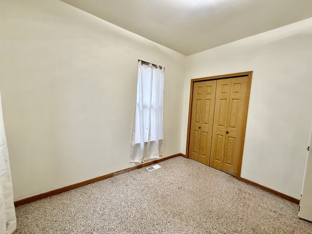 unfurnished bedroom with a closet and carpet floors