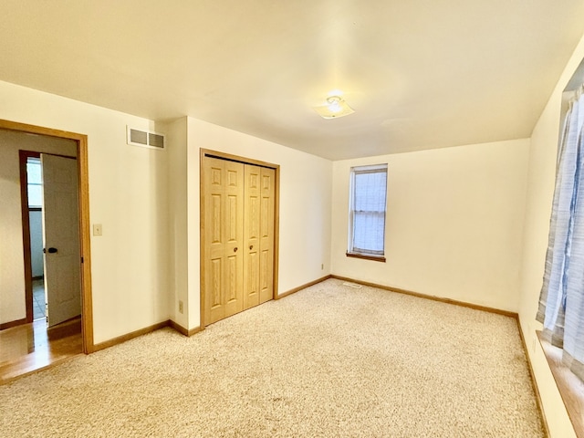 unfurnished bedroom featuring carpet flooring and a closet