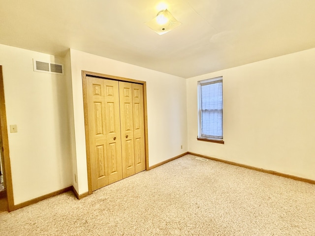 unfurnished bedroom featuring carpet flooring and a closet