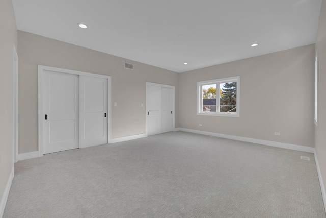 unfurnished bedroom featuring baseboards, two closets, and recessed lighting