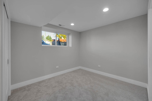 spare room with light carpet, recessed lighting, visible vents, and baseboards