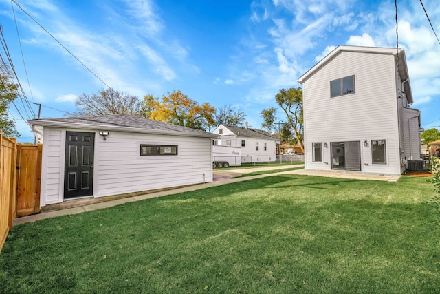 back of house featuring an outbuilding, central air condition unit, a lawn, a patio area, and fence