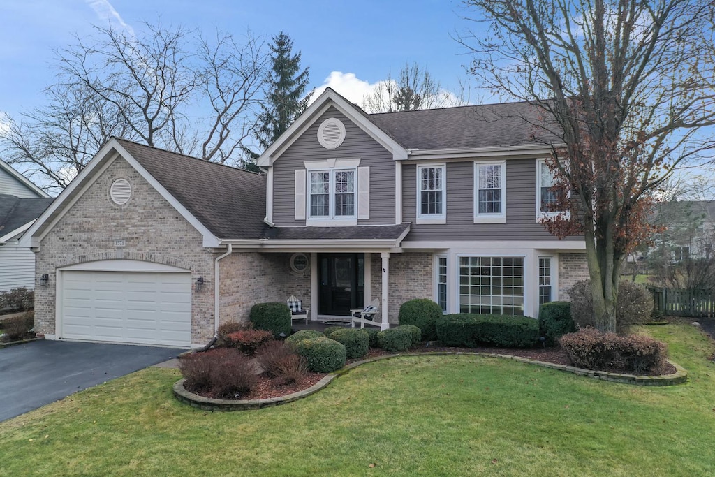 view of front of home with a front lawn and a garage