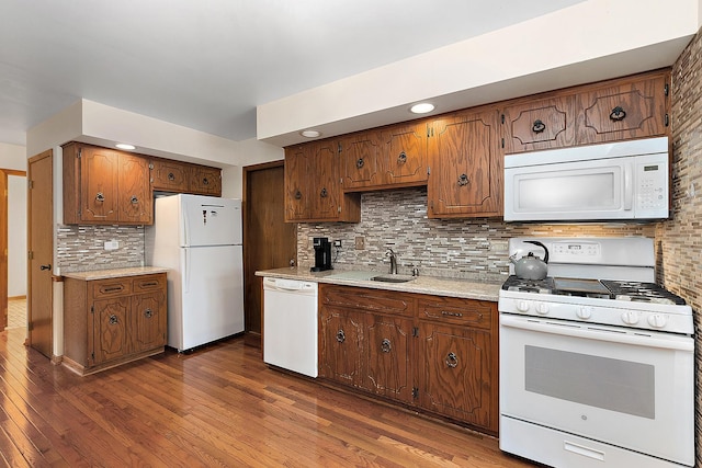 kitchen featuring white appliances, backsplash, dark hardwood / wood-style floors, and sink