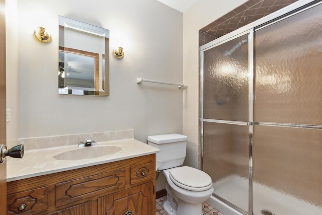 bathroom featuring tile patterned floors, vanity, a shower with shower door, and toilet