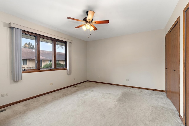 carpeted spare room with ceiling fan