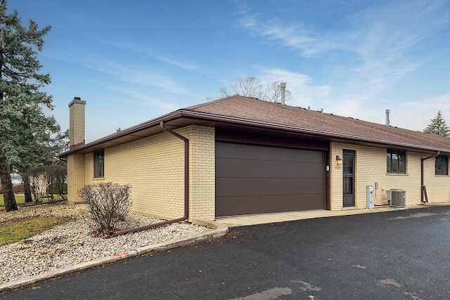 exterior space with a garage and central AC