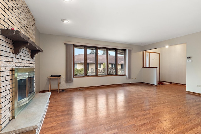 unfurnished living room with a fireplace and hardwood / wood-style flooring