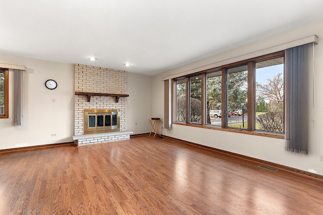 unfurnished living room with wood-type flooring and a fireplace