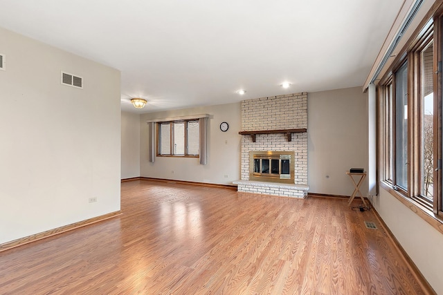 unfurnished living room featuring a fireplace and light hardwood / wood-style flooring