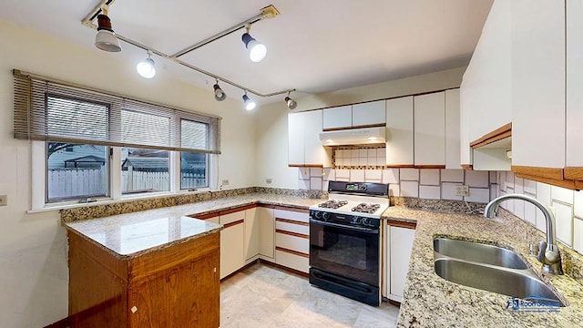 kitchen featuring kitchen peninsula, light stone countertops, sink, white cabinets, and black electric range oven