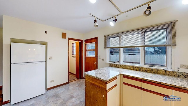 kitchen with white fridge and light stone counters