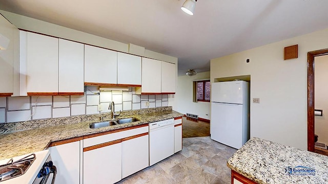 kitchen with white cabinetry, sink, light stone countertops, and white appliances