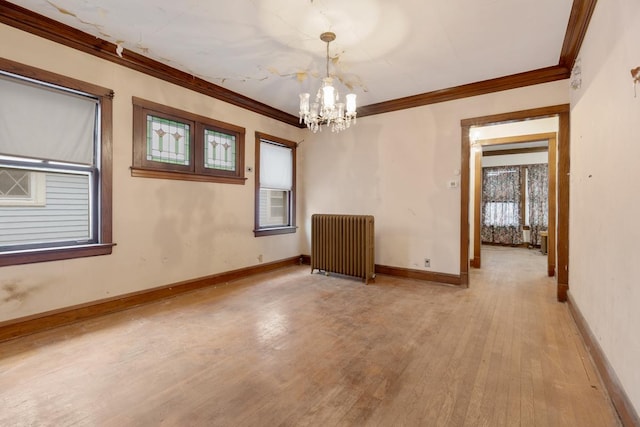 unfurnished room featuring light hardwood / wood-style floors, radiator heating unit, ornamental molding, and a notable chandelier