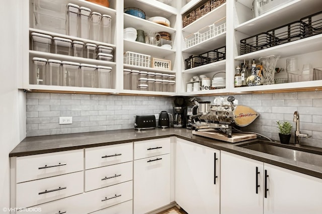 kitchen with white cabinetry, sink, and decorative backsplash