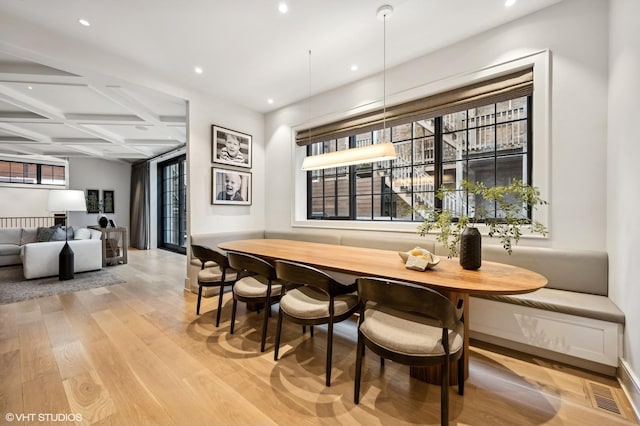 bar featuring coffered ceiling, beamed ceiling, hanging light fixtures, light wood-type flooring, and breakfast area