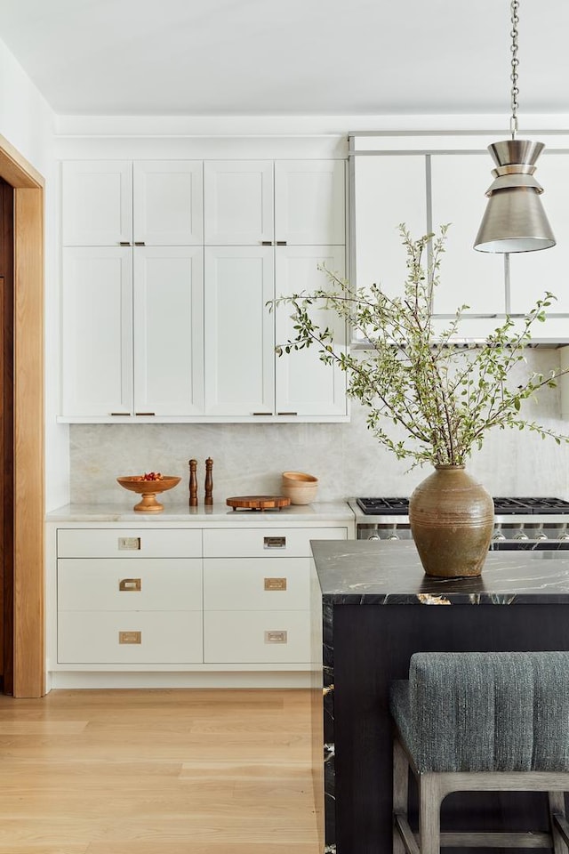 bar with white cabinets and light wood-type flooring