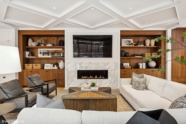 living room with coffered ceiling, a fireplace, and built in shelves