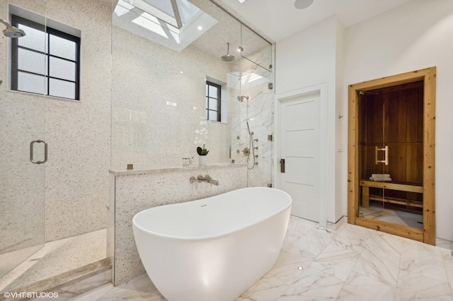 bathroom featuring tile walls, a skylight, a wealth of natural light, and plus walk in shower