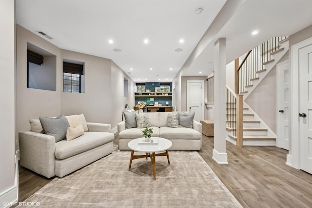 living room with wood-type flooring and built in features