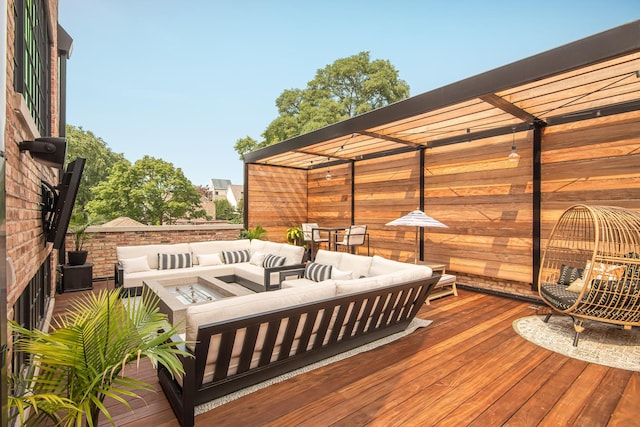 wooden deck featuring a pergola and an outdoor living space with a fire pit