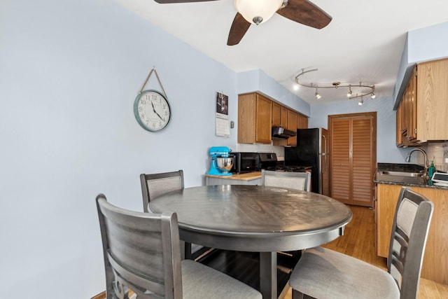 dining room with ceiling fan and sink