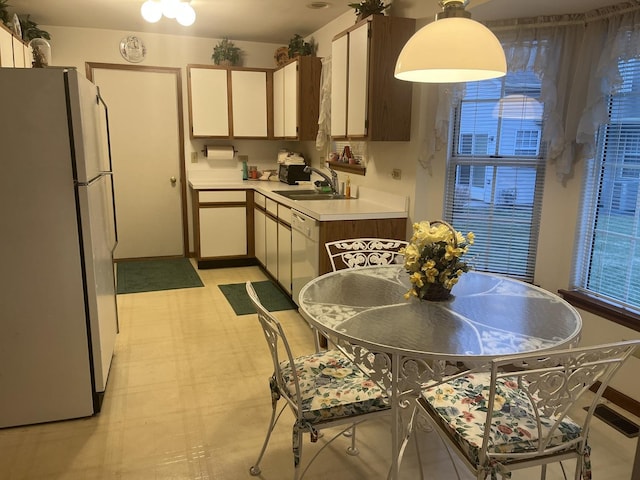 kitchen with white appliances, white cabinetry, and sink