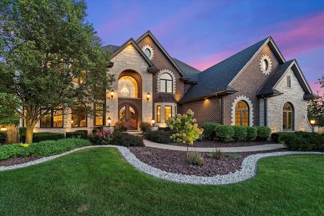 french country style house featuring french doors and a lawn