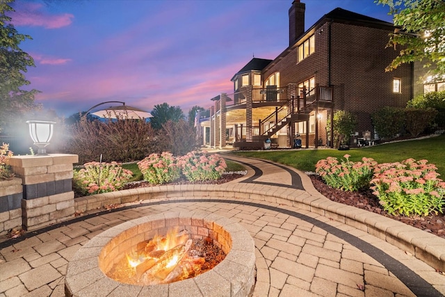 exterior space with a balcony and a fire pit