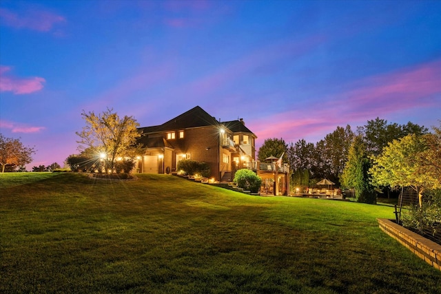 property exterior at dusk featuring a lawn