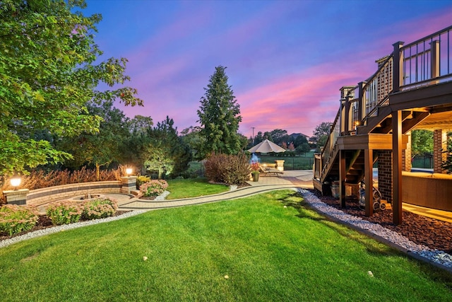 yard at dusk featuring a patio area and a wooden deck