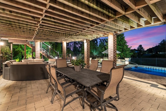 patio terrace at dusk with a fenced in pool and outdoor lounge area