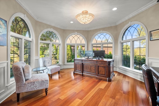 office area with crown molding, an inviting chandelier, and light wood-type flooring