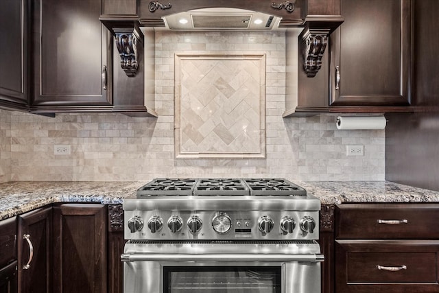 kitchen with backsplash, light stone countertops, and stainless steel stove