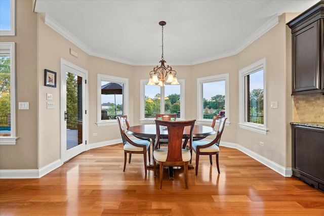 dining room featuring crown molding, light hardwood / wood-style flooring, and a notable chandelier