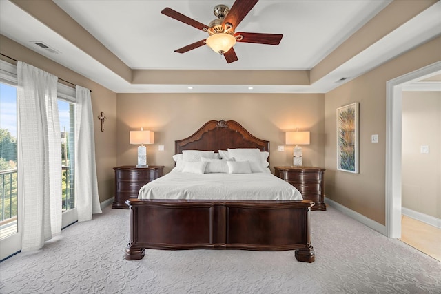 bedroom featuring a raised ceiling, ceiling fan, light colored carpet, and access to outside