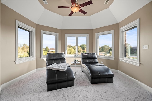 sitting room with a raised ceiling, a wealth of natural light, ceiling fan, and light carpet