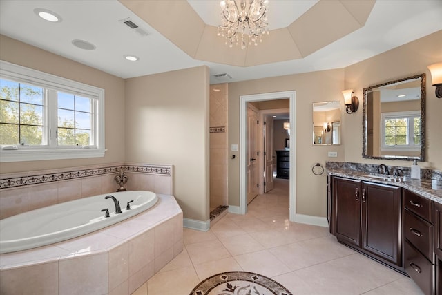 bathroom with vanity, tile patterned flooring, a tray ceiling, tiled bath, and a chandelier