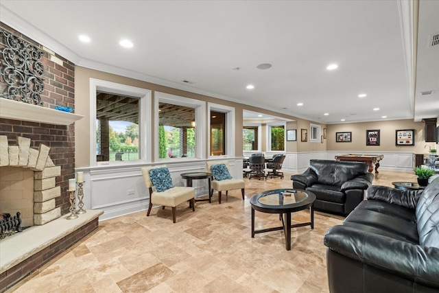 living room featuring crown molding, billiards, and a brick fireplace