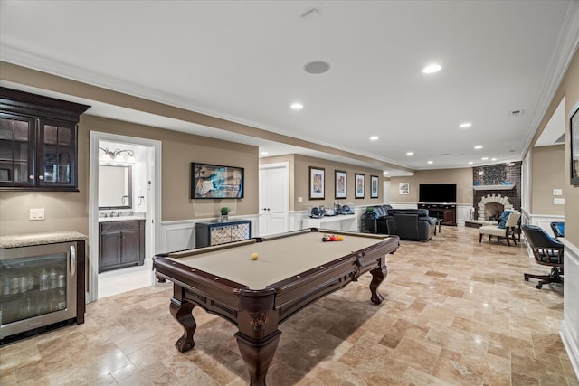 recreation room with a fireplace, wine cooler, crown molding, and billiards