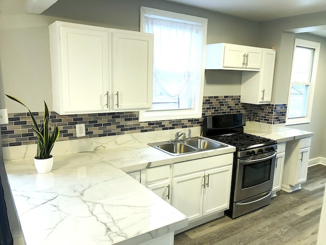 kitchen with white cabinets, stainless steel range with gas cooktop, light stone countertops, and sink