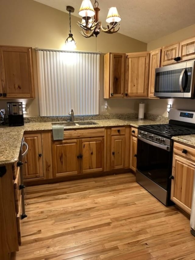 kitchen featuring sink, a chandelier, decorative light fixtures, and appliances with stainless steel finishes