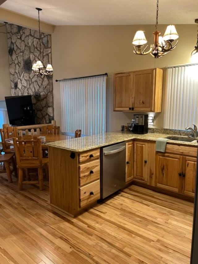 kitchen featuring kitchen peninsula, stainless steel dishwasher, decorative light fixtures, and a notable chandelier