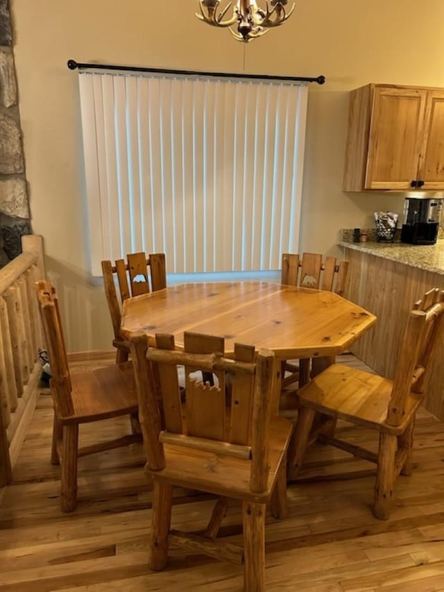 dining area featuring light hardwood / wood-style floors and an inviting chandelier