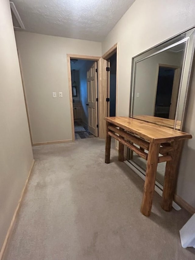 corridor featuring carpet and a textured ceiling