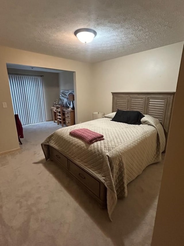 bedroom with light carpet and a textured ceiling