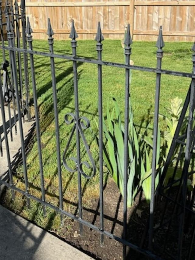 view of gate with a lawn