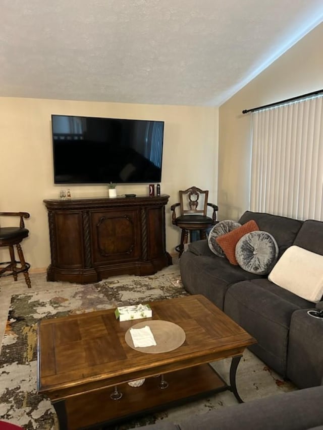 carpeted living room with a textured ceiling and vaulted ceiling