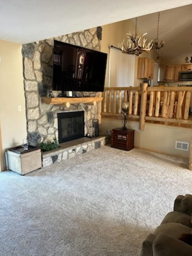 carpeted living room with a fireplace and an inviting chandelier