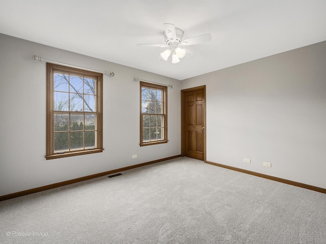 carpeted spare room with ceiling fan